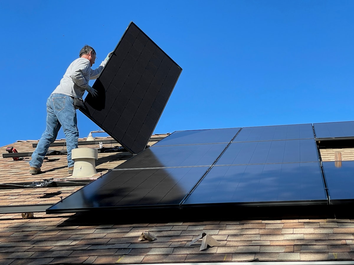 Técnico instalando un panel solar en el techo de una casa